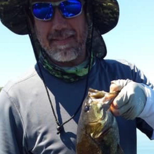 Man holding fish caught from Woodruff pond